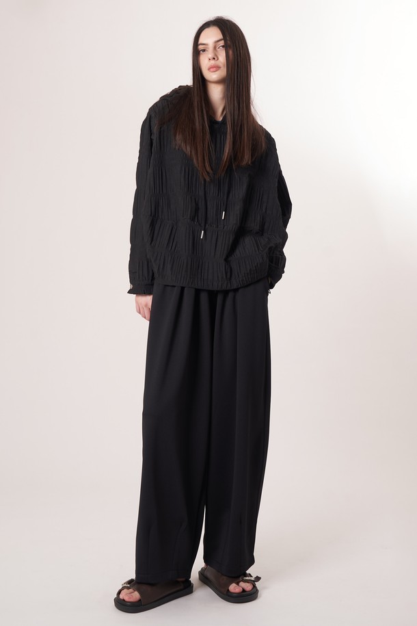 AU52PT39 더블 테크 와이드 팬츠_블랙은 미니멀, 클래식, 시크 스타일을 추구하는 고객을 위한 사계절용 와이드 팬츠입니다. 밴딩 처리되어 편안한 착용감을 제공하며, 일상과 출근룩, 모임룩 등 다양한 TPO에 활용하기 좋습니다. 부드러운 촉감의 폴리에스테르, 폴리우레탄 혼방 소재로 제작되었으며, 두꺼운 두께감과 루즈핏으로 안정적인 핏을 연출합니다. 더블 레이어드 기능성 원단과 압축 가공, 앞면 플리츠 디테일, 드로우스트링 디자인이 특징입니다.
