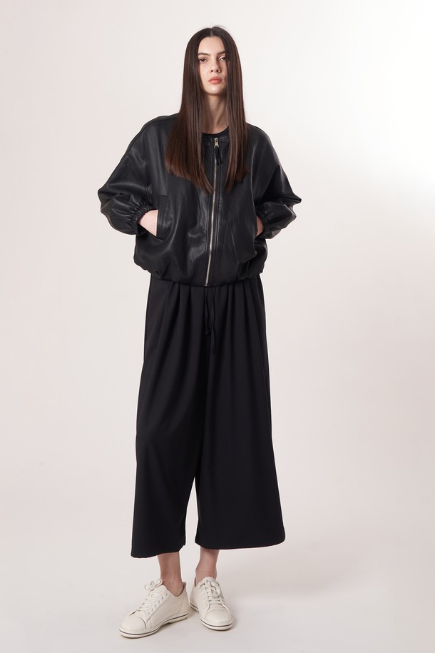 AU52PT33 F 와이드 크롭 팬츠_블랙은 미니멀하고 베이직한 스타일의 여성용 와이드 크롭 팬츠입니다. 봄, 여름, 가을 계절에 적합하며, 얇고 부드러운 촉감의 폴리에스테르, 레이온, 폴리우레탄 혼방 소재로 제작되어 편안한 착용감을 선사합니다. 허리 밴딩과 드로우스트링 디테일로 편안함을 더했으며, 넉넉한 루즈핏으로 활동성을 높였습니다. 데이트룩, 카페룩 등 다양한 TPO에 활용하기 좋으며, 남녀 공용으로 착용 가능합니다.
