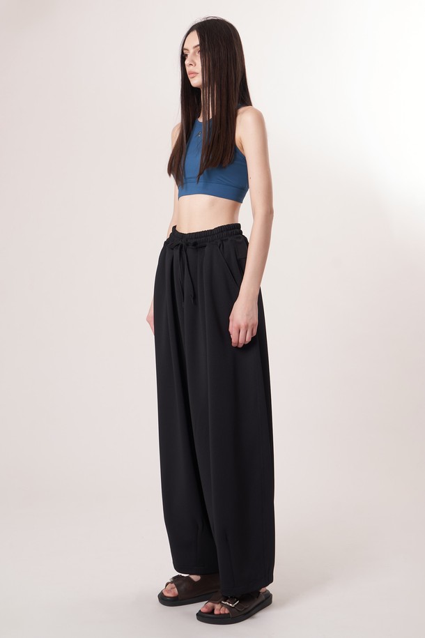 AU52PT39 더블 테크 와이드 팬츠_블랙은 미니멀, 클래식, 시크 스타일을 추구하는 고객을 위한 사계절용 와이드 팬츠입니다. 밴딩 처리되어 편안한 착용감을 제공하며, 일상과 출근룩, 모임룩 등 다양한 TPO에 활용하기 좋습니다. 부드러운 촉감의 폴리에스테르, 폴리우레탄 혼방 소재로 제작되었으며, 두꺼운 두께감과 루즈핏으로 안정적인 핏을 연출합니다. 더블 레이어드 기능성 원단과 압축 가공, 앞면 플리츠 디테일, 드로우스트링 디자인이 특징입니다.
