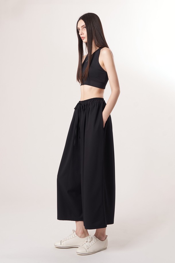 AU52PT33 F 와이드 크롭 팬츠_블랙은 미니멀하고 베이직한 스타일의 여성용 와이드 크롭 팬츠입니다. 봄, 여름, 가을 계절에 적합하며, 얇고 부드러운 촉감의 폴리에스테르, 레이온, 폴리우레탄 혼방 소재로 제작되어 편안한 착용감을 선사합니다. 허리 밴딩과 드로우스트링 디테일로 편안함을 더했으며, 넉넉한 루즈핏으로 활동성을 높였습니다. 데이트룩, 카페룩 등 다양한 TPO에 활용하기 좋으며, 남녀 공용으로 착용 가능합니다.
