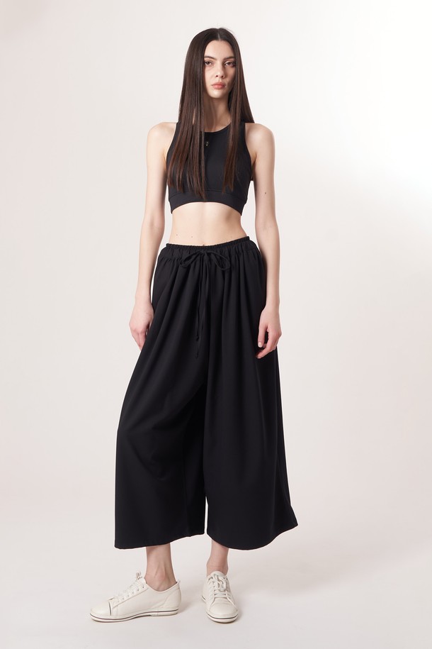 AU52PT33 F 와이드 크롭 팬츠_블랙은 미니멀하고 베이직한 스타일의 여성용 와이드 크롭 팬츠입니다. 봄, 여름, 가을 계절에 적합하며, 얇고 부드러운 촉감의 폴리에스테르, 레이온, 폴리우레탄 혼방 소재로 제작되어 편안한 착용감을 선사합니다. 허리 밴딩과 드로우스트링 디테일로 편안함을 더했으며, 넉넉한 루즈핏으로 활동성을 높였습니다. 데이트룩, 카페룩 등 다양한 TPO에 활용하기 좋으며, 남녀 공용으로 착용 가능합니다.
