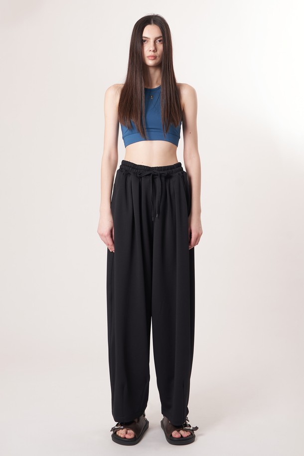 AU52PT39 더블 테크 와이드 팬츠_블랙은 미니멀, 클래식, 시크 스타일을 추구하는 고객을 위한 사계절용 와이드 팬츠입니다. 밴딩 처리되어 편안한 착용감을 제공하며, 일상과 출근룩, 모임룩 등 다양한 TPO에 활용하기 좋습니다. 부드러운 촉감의 폴리에스테르, 폴리우레탄 혼방 소재로 제작되었으며, 두꺼운 두께감과 루즈핏으로 안정적인 핏을 연출합니다. 더블 레이어드 기능성 원단과 압축 가공, 앞면 플리츠 디테일, 드로우스트링 디자인이 특징입니다.
