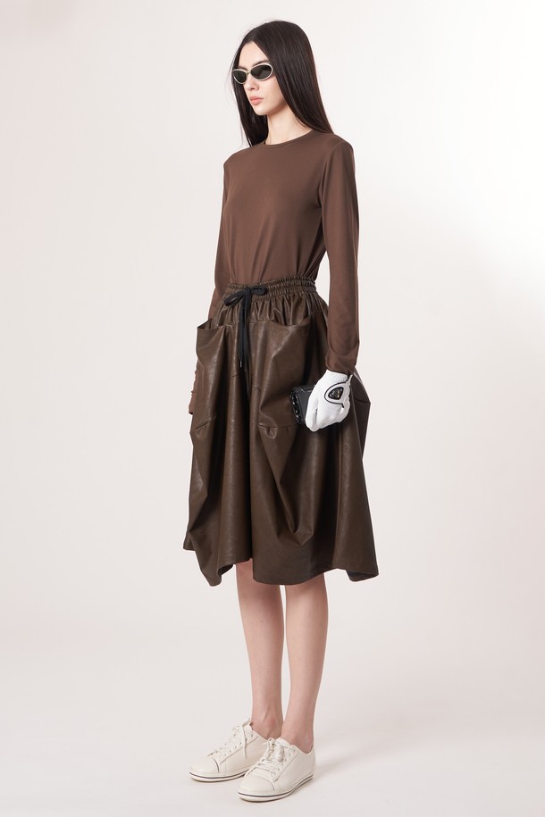 AW52PT32 레더 이펙트 플레어 팬츠_다크브라운은 여성용 플레어 팬츠입니다. 레더 이펙트 소재로 제작되어 부드러운 촉감과 자연스러운 주름 텍스처를 선사하며, 루즈핏으로 편안하게 착용 가능합니다. 다크브라운 컬러의 긴 기장으로, 엘레강스한 스타일을 연출하며, 데이트룩, 모임룩, 오피스룩 등 다양한 TPO에 활용할 수 있습니다. 클래식, 미니멀, 시크 스타일을 선호하는 분들에게 추천합니다. 입체감 있는 실루엣이 특징입니다.
