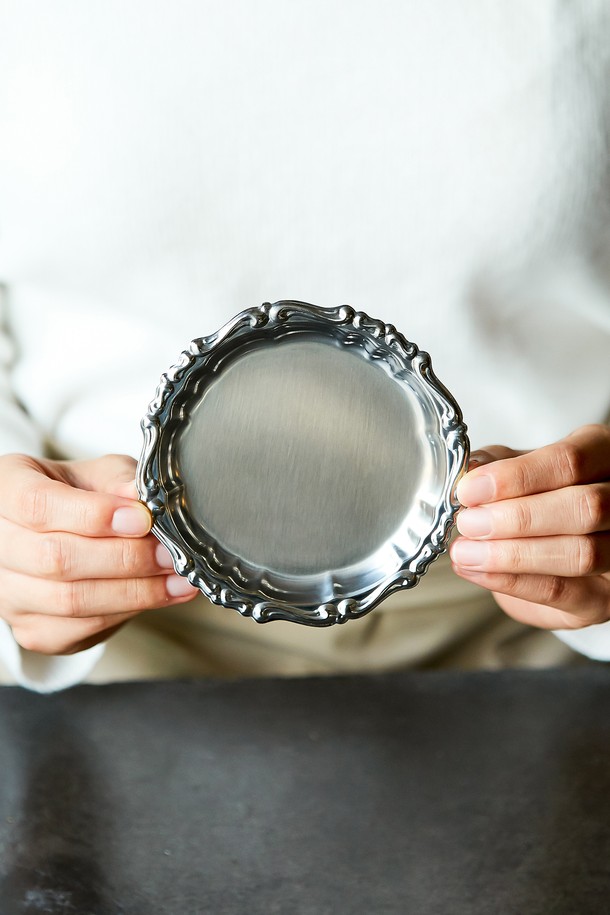 [모타] 바로크 코스터+접시 선물세트는 스테인리스스틸 소재에 실버 컬러의 고급스러운 바로크 패턴 디자인이 돋보이는 주방용품입니다. 매트 피니시 마감으로 세련된 분위기를 더하며, 음료 코스터, 디저트/스낵 플레이트, 장식용 등 다용도로 활용 가능합니다. 내구성이 뛰어나고 위생적인 관리가 용이하며, 클래식하면서도 모던한 스타일로 주방에 우아함을 더해줍니다.
