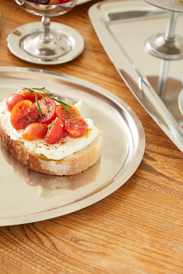 [모타] 모던 타원형 트레이35는 심플하고 깔끔한 디자인의 주방용품입니다. 음식 서빙, 파티 플레이팅, 또는 일상용품 진열에 활용하기 좋습니다. 스테인리스 소재로 제작되어 위생적이며 내구성이 뛰어나고 가벼운 무게감과 편안한 그립감을 제공합니다. 과일, 디저트, 핑거푸드 등을 서빙하는 다용도 트레이로, 식기나 유리/도자기와 조화롭게 매칭되어 테이블에 포인트를 더합니다.
