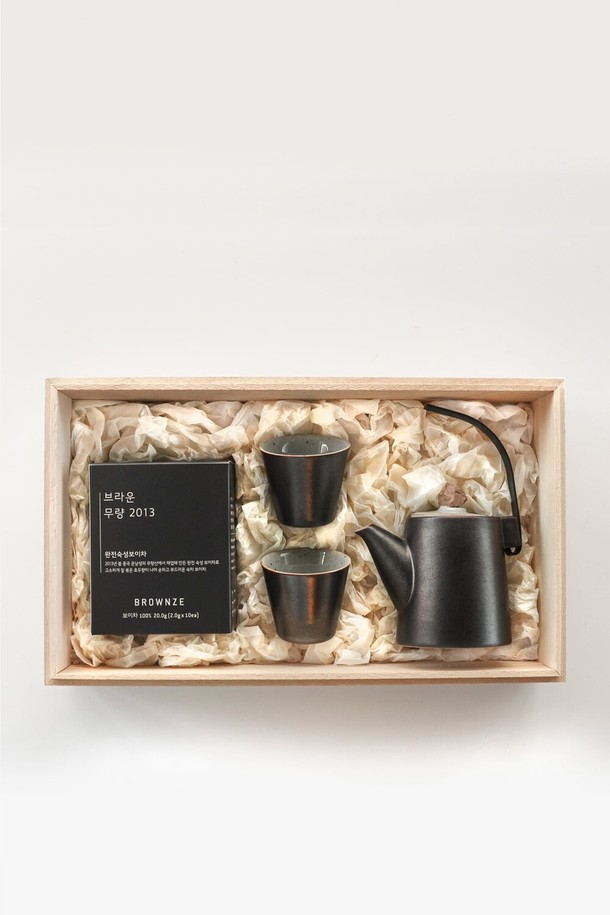 [브라운즈] 저녁바람 숙차 보이차 다도 선물세트는 숙차 보이차 티백과 도자기 다관 세트로 구성된 2인용 선물 세트입니다. 중국 운남성 무량산에서 생산된 무량 2013 보이차 티백(10개입)과 국산 도자기로 제작된 다관 1개, 찻잔 2개로 구성되어 있습니다. 오동나무 상자에 담겨 선물하기 좋으며, 블랙&화이트 색상의 무지 디자인으로 심플하고 모던한 다도 시간을 선사합니다.
