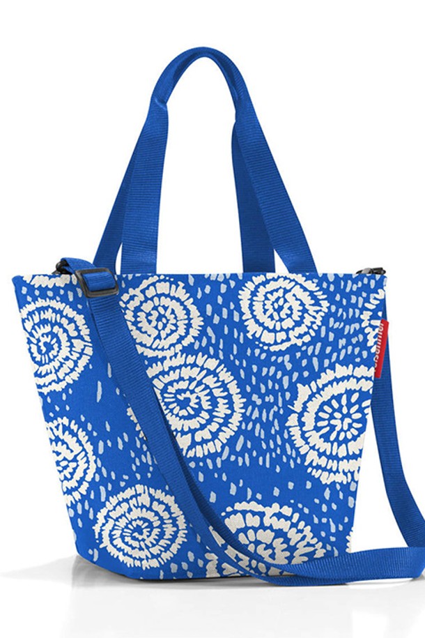 [라이젠탈] 쇼퍼백 XS 바틱스트롱블루 RSTZR4070은 여성용 쇼퍼백으로, 바틱 플로럴 패턴의 블루 컬러가 돋보입니다. 가볍고 튼튼한 폴리에스테르 소재에 생활 방수 기능을 더해 실용성을 높였으며, 내부 지퍼 포켓과 토트백/크로스백 겸용 디자인으로 활용도를 높였습니다. 가로 31cm, 세로 21cm, 폭 16cm, 4L 용량의 XS 사이즈로, 여행, 쇼핑 등 일상에서 간편하게 사용할 수 있으며, 탈부착 가능한 어깨끈과 재활용 PET병으로 제작된 친환경적인 제품입니다.
