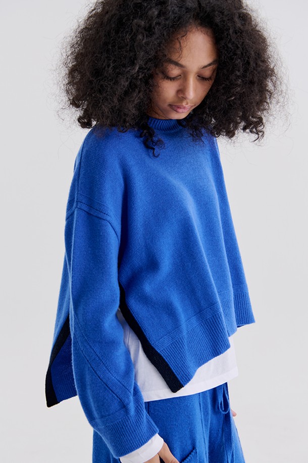 **SIDE OPEN PULLOVER (BLUE)**

부드러운 울과 캐시미어 혼방 소재로 제작되어 포근한 착용감을 선사하는 사이드 오픈 풀오버입니다. 라운드넥 디자인에 롱 기장으로, 캐주얼하면서도 유니크한 스타일을 연출합니다. 깊이 있는 블루 컬러와 옆트임, 언밸런스 기장, 컬러 블록 디테일이 돋보이는 디자인입니다. 가을, 겨울 시즌 데이트룩이나 모임룩으로, 미니멀, 클래식한 무드로도 활용하기 좋습니다. 루즈핏으로 편안하게 착용 가능하며, 긴 소매 기장으로 따뜻함을 더했습니다.
