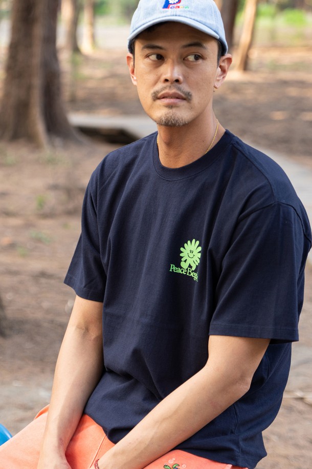 플라워, 로고, 프린트 패턴이 돋보이는 네이비 블루 컬러의 FLOWER RUN PEACE RUN 티셔츠입니다. 러닝 및 일상생활에 적합하며, 봄/여름 시즌에 스포티하고 캐주얼한 스타일을 연출할 수 있습니다. 라바나염 프린트, 어깨 체인 스티치, 소매/하단 더블 스티치 등 디테일을 더했으며, 뒤틀림이 적은 면 원사를 사용하여 제작된 남녀 공용 레귤러핏/오버핏 반소매 라운드넥 티셔츠입니다.
