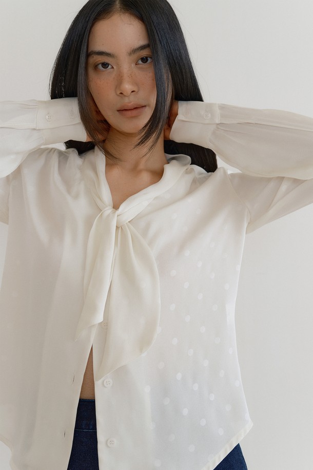 실큰 스카프 블라우스 (dot cream)는 부드러운 촉감의 실키한 새틴 폴리에스테르 소재로 제작된 여성 블라우스입니다. 은은한 광택감이 돋보이는 크림 컬러에 클래식하고 우아한 무드의 도트 패턴이 더해져 세련된 분위기를 연출합니다. 루즈핏에 V넥 디자인, 스카프 디테일, 긴 소매 기장으로 편안하면서도 여성스러운 실루엣을 선사합니다. 데이트룩, 카페룩, 모임룩 등 다양한 TPO에 맞춰 클래식, 미니멀, 로맨틱 스타일을 연출해보세요. 자연스러운 드레이프성이 특징으로, 봄, 여름, 가을 시즌에 활용하기 좋습니다.
