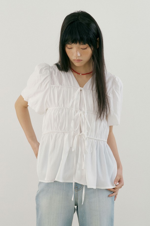 엘라 스트링 블라우스 (화이트)는 여성스러운 무드를 연출하는 여름용 블라우스입니다. 부드러운 레이온과 면 혼방 소재로 제작되어 얇고 가벼운 착용감을 선사하며, 루즈핏 디자인으로 편안함을 더합니다. 브이넥 라인과 반소매 기장으로 시원함을 강조하고, 리본 디테일과 앞중심 히든 후크 디테일이 여성스러움을 더합니다. 데이트룩, 카페룩, 모임룩 등 다양한 TPO에 어울리며, 미니멀, 클래식, 로맨틱 스타일을 즐기는 분들께 추천합니다. 레이어드하여 다양한 스타일을 연출할 수 있습니다.
