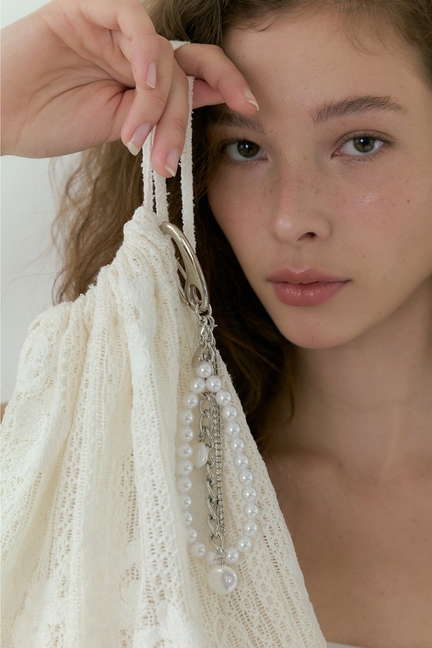 Lucirzu 펄 비즈 키링 (아이보리)은 여성 고객을 위한 페미닌하고 트렌디한 스타일의 키링입니다. 아이보리 컬러의 펄과 체인, 로고 장식이 조화롭게 어우러져 고급스러운 분위기를 연출하며, 3개의 펄 장식과 체인 레이어드 디자인이 돋보입니다. 링 높이 4.5cm, 총길이 16.5cm의 넉넉한 사이즈로 제작되었으며, 탈부착이 가능하여 실용성을 더했습니다.
