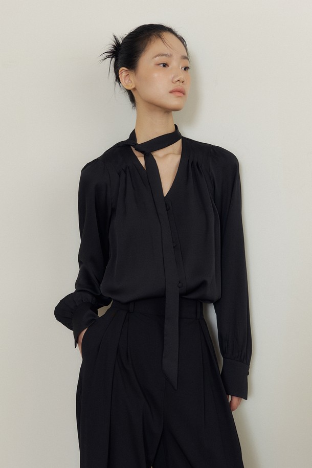 블랙 색상의 Soft Drape Tie-Neck V-블라우스입니다. 부드러운 촉감과 얇은 두께로 봄, 가을에 적합하며, 우아하고 미니멀한 스타일을 연출합니다. 루즈 핏에 긴 소매 기장으로 편안함을 더하고, 드레이프 디테일과 타이넥 디자인이 특징입니다. 오피스룩, 데이트룩, 모임룩 등 다양한 TPO에 클래식, 미니멀, 시크한 무드로 활용할 수 있습니다. V넥과 리본넥으로 연출 가능하며, 무지 패턴으로 어떤 하의와도 쉽게 매치됩니다.
