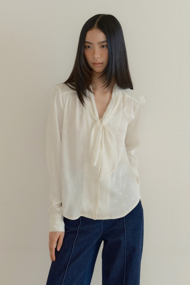 실큰 스카프 블라우스 (dot cream)는 부드러운 촉감의 실키한 새틴 폴리에스테르 소재로 제작된 여성 블라우스입니다. 은은한 광택감이 돋보이는 크림 컬러에 클래식하고 우아한 무드의 도트 패턴이 더해져 세련된 분위기를 연출합니다. 루즈핏에 V넥 디자인, 스카프 디테일, 긴 소매 기장으로 편안하면서도 여성스러운 실루엣을 선사합니다. 데이트룩, 카페룩, 모임룩 등 다양한 TPO에 맞춰 클래식, 미니멀, 로맨틱 스타일을 연출해보세요. 자연스러운 드레이프성이 특징으로, 봄, 여름, 가을 시즌에 활용하기 좋습니다.
