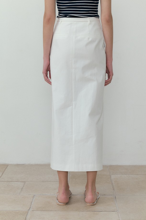 아이보리 컬러의 슬릿 포인트 벨티드 롱스커트입니다. 면과 폴리에스테르 혼방 소재로 제작되어 부드러운 촉감과 가벼운 착용감을 선사하며, H라인 핏과 레귤러핏으로 편안하게 착용할 수 있습니다. 허리 벨트와 D링 장식, 앞트임, 싱글 플리츠 디테일이 더해져 페미닌하면서도 캐주얼한 무드를 연출하며 여름철 일상복으로 활용하기 좋습니다.
