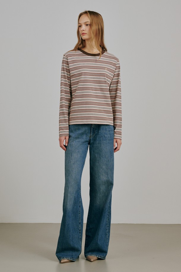 베이지 컬러의 스트라이프 롱 슬리브 티셔츠입니다. 면과 폴리에스테르 혼방 소재로 제작되어 부드러운 촉감과 중간 두께로 봄, 가을에 착용하기 좋습니다. 라운드넥에 레귤러핏으로 편안하게 연출 가능하며, 캐주얼, 미니멀, 클래식 스타일을 모두 소화합니다. 메탈 로고 디테일이 돋보이며, 모던한 실루엣과 프리미엄 소재감이 특징입니다. 카페룩이나 동네 마실룩에 잘 어울리는 아이템입니다.
