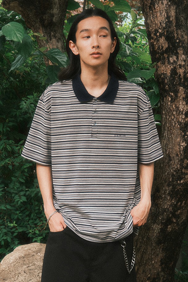 네이비 색상의 스트라이프 폴로 셔츠입니다. 면과 폴리에스테르 혼방 소재로 제작되어 가볍고 드라이한 촉감과 쾌적한 착용감을 선사하며, 봄, 여름 시즌에 적합합니다. 클래식하고 베이직한 스타일의 반소매 디자인에 여유 있는 핏으로 편안함을 더하고, 양옆 트임과 전면 자수 로고, 버튼 여밈 디테일로 포인트를 주어 데일리룩과 캐주얼룩에 활용하기 좋습니다.
