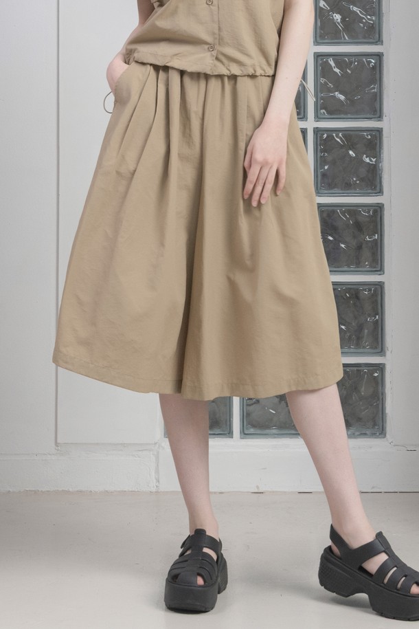 뒤란 리츠 와이드 큐롯 스커트 팬츠는 페미닌한 무드의 여성용 큐롯 팬츠로, 봄, 여름에 시원하게 착용하기 좋습니다. 베이지, 블루, 블랙 3가지 색상으로 출시되었으며, 얇은 두께의 나일론 소재에 루즈핏 와이드 디자인으로 편안한 착용감을 제공합니다. 앞뒤 플리츠 디테일과 자연스러운 드레이프, 사이드 포켓, 신축성 있는 허리 밴딩으로 실용성을 더했습니다.
