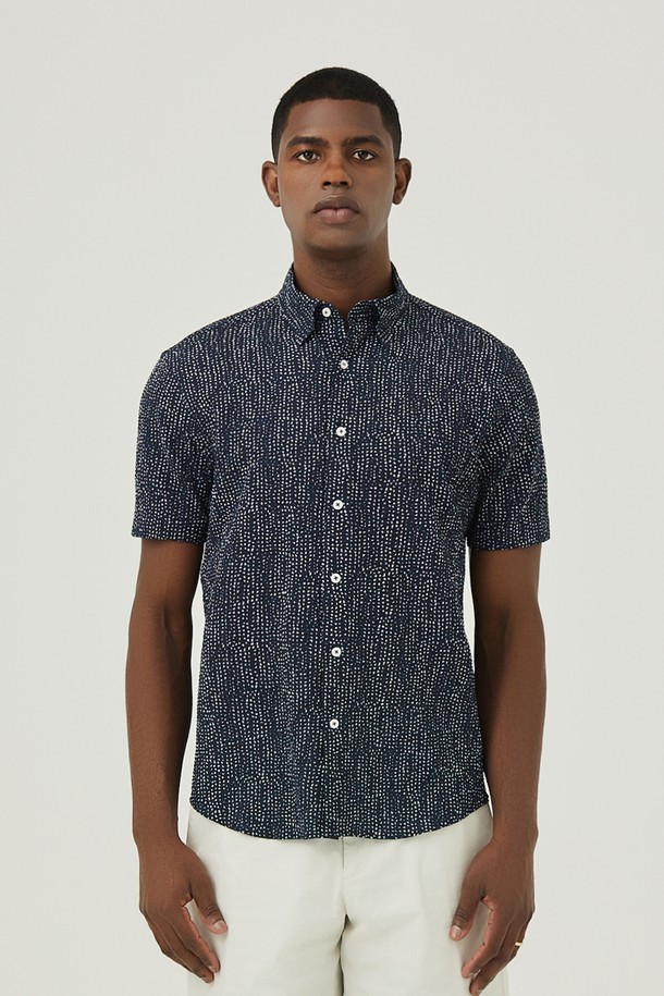 네이비 컬러의 도트 무늬가 돋보이는 남성용 셔츠입니다. 부드러운 면 소재에 통기성이 좋은 서커 원단을 사용하여 여름철에도 시원하고 쾌적하게 착용할 수 있습니다. 캐주얼하고 미니멀한 스타일로, 휴가룩이나 여행룩에 활용하기 좋으며, 버튼 여밈과 차이나 칼라 디자인으로 깔끔한 인상을 줍니다.
