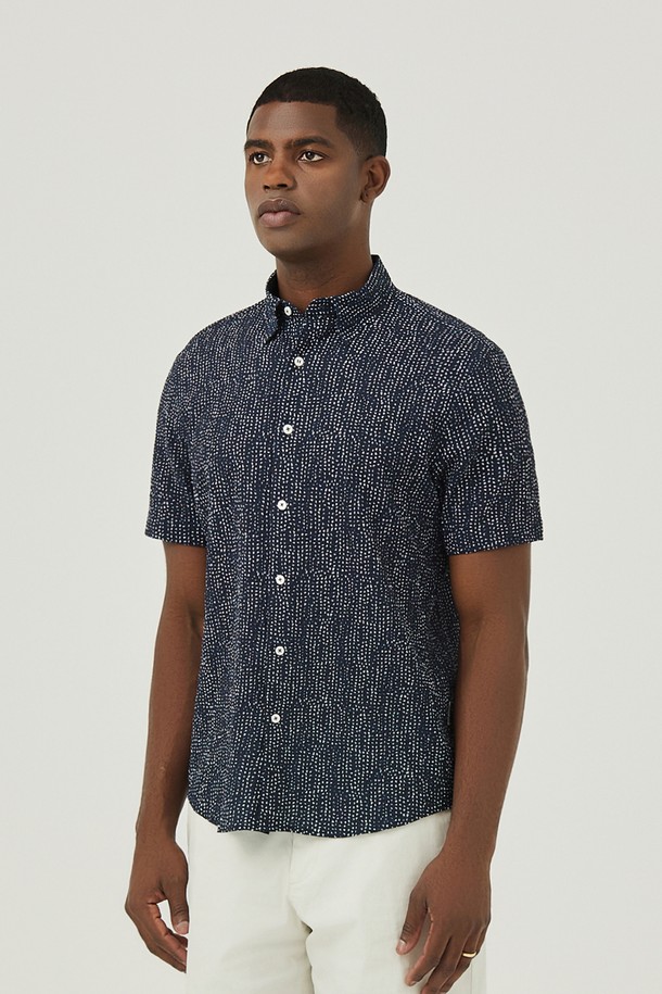 네이비 컬러의 도트 무늬가 돋보이는 남성용 셔츠입니다. 부드러운 면 소재에 통기성이 좋은 서커 원단을 사용하여 여름철에도 시원하고 쾌적하게 착용할 수 있습니다. 캐주얼하고 미니멀한 스타일로, 휴가룩이나 여행룩에 활용하기 좋으며, 버튼 여밈과 차이나 칼라 디자인으로 깔끔한 인상을 줍니다.
