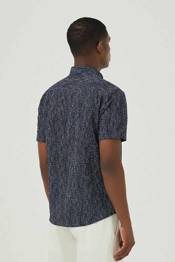 네이비 컬러의 도트 무늬가 돋보이는 남성용 셔츠입니다. 부드러운 면 소재에 통기성이 좋은 서커 원단을 사용하여 여름철에도 시원하고 쾌적하게 착용할 수 있습니다. 캐주얼하고 미니멀한 스타일로, 휴가룩이나 여행룩에 활용하기 좋으며, 버튼 여밈과 차이나 칼라 디자인으로 깔끔한 인상을 줍니다.

