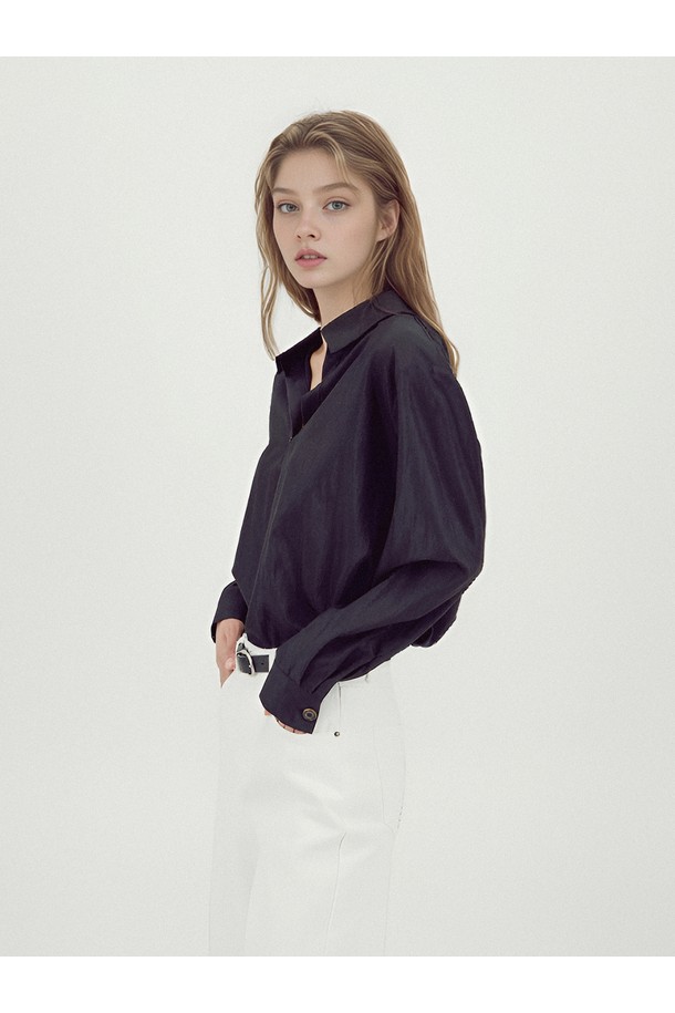 [25FW] 글로시 셔츠 블라우스 _블랙은 미니멀하고 클래식한 스타일을 추구하는 여성들을 위한 셔츠/블라우스입니다. 부드러운 촉감의 레이온과 나일론 혼방 소재로 제작되었으며, 사계절 내내 착용 가능합니다. 블랙 컬러, 루즈핏, 얇은 두께로 편안한 착용감을 선사하며 오피스룩, 출근룩, 모임룩 등 다양한 TPO에 활용하기 좋습니다. 미니 칼라 디자인과 메탈 로고 프린트 칼라, 로고 버튼 디테일, 소매 개더링, 광택감 있는 소재가 특징입니다. 긴 소매 기장으로 시크한 무드를 연출합니다.
