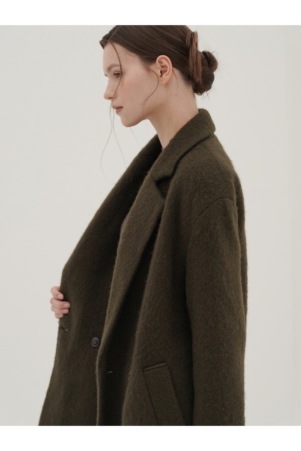 [25FW] 알파카 더블 코트 _브라운은 여성용 아우터로, 가을과 겨울에 어울리는 미디엄 기장의 더블 코트입니다. 부드러운 촉감의 알파카 소재로 제작되어 따뜻하고 포근한 착용감을 선사하며, 오버핏 디자인과 넉넉한 실루엣으로 편안한 스타일을 연출합니다. 브라운 컬러의 무지 디자인은 미니멀하고 클래식한 분위기를 자아내 오피스룩, 모임룩, 데이트룩 등 다양한 TPO에 활용 가능합니다. 와이드 라펠과 긴 소매는 시크한 스타일을 완성하며, 더블 버튼 여밈으로 세련된 느낌을 더했습니다.
