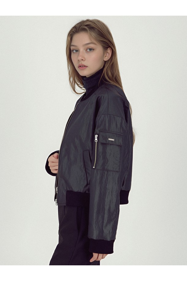 **[25FW]** 글로시 봄버 재킷 _블랙은 미니멀하고 캐주얼한 감각을 더해줄 여성용 아우터입니다. 가을, 겨울 시즌에 적합하며, 세미 루즈핏으로 편안하게 착용할 수 있습니다. 광택감 있는 나일론 소재로 제작되어 시크한 분위기를 연출하며, 지퍼 여밈 방식과 소매 지퍼 디테일로 포인트를 더했습니다. 크롭 기장으로 트렌디함을 살렸으며, 슬리브 포켓, 메탈 로고 장식, 입체 포켓 등의 디테일이 돋보입니다. 겨울 데일리룩에 활용하기 좋은 아이템으로, 비스코스와 폴리에스터 안감으로 따뜻함을 더했습니다.
