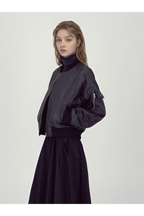 **[25FW]** 글로시 봄버 재킷 _블랙은 미니멀하고 캐주얼한 감각을 더해줄 여성용 아우터입니다. 가을, 겨울 시즌에 적합하며, 세미 루즈핏으로 편안하게 착용할 수 있습니다. 광택감 있는 나일론 소재로 제작되어 시크한 분위기를 연출하며, 지퍼 여밈 방식과 소매 지퍼 디테일로 포인트를 더했습니다. 크롭 기장으로 트렌디함을 살렸으며, 슬리브 포켓, 메탈 로고 장식, 입체 포켓 등의 디테일이 돋보입니다. 겨울 데일리룩에 활용하기 좋은 아이템으로, 비스코스와 폴리에스터 안감으로 따뜻함을 더했습니다.
