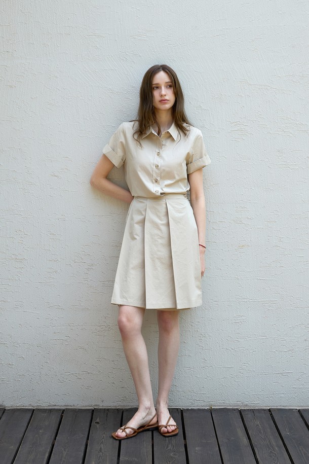 **로우 플리츠 코튼원피스**는 여름철 시원하고 편안하게 즐길 수 있는 여성용 원피스입니다. 부드러운 촉감의 고밀도 코튼 트윌 소재로 제작되어 비침 걱정 없이 착용 가능하며, 셔츠 칼라와 앞면 버튼 여밈 디테일이 특징입니다. 뒷면 허리 스트링으로 실루엣을 조절하여 모던한 스타일을 연출할 수 있으며, 플리츠 디테일이 여성스러운 분위기를 더합니다. 베이지와 블랙 두 가지 컬러로 출시되어 일상 및 여행, 휴가룩 등 다양한 TPO에 맞춰 활용하기 좋습니다. 루즈핏으로 편안함을 강조한 디자인이 돋보입니다.
