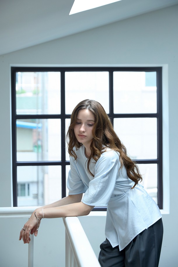 **라인 볼륨 랩블라우스**

페미닌한 무드의 여성 블라우스입니다. 라운드넥 디자인에 가볍고 부드러운 레이온, 나일론 혼방 소재로 제작되어 봄, 여름에 시원하게 착용하기 좋습니다. 그레이, 그레이블루, 아이보리 세 가지 컬러로 출시되었습니다. 뒷목 버튼 여밈과 앞 슬릿 스트링 디테일, 벌룬 소매 디자인으로 포인트를 더했습니다. 스트링으로 허리 실루엣을 조절하여 다양한 스타일 연출이 가능하며, 데이트룩, 카페룩, 모임룩 등 다양한 TPO에 활용할 수 있습니다. 클래식, 미니멀, 로맨틱 스타일을 즐겨 입는 분들께 추천합니다.
