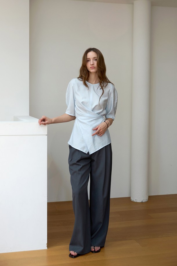 **라인 볼륨 랩블라우스**

페미닌한 무드의 여성 블라우스입니다. 라운드넥 디자인에 가볍고 부드러운 레이온, 나일론 혼방 소재로 제작되어 봄, 여름에 시원하게 착용하기 좋습니다. 그레이, 그레이블루, 아이보리 세 가지 컬러로 출시되었습니다. 뒷목 버튼 여밈과 앞 슬릿 스트링 디테일, 벌룬 소매 디자인으로 포인트를 더했습니다. 스트링으로 허리 실루엣을 조절하여 다양한 스타일 연출이 가능하며, 데이트룩, 카페룩, 모임룩 등 다양한 TPO에 활용할 수 있습니다. 클래식, 미니멀, 로맨틱 스타일을 즐겨 입는 분들께 추천합니다.
