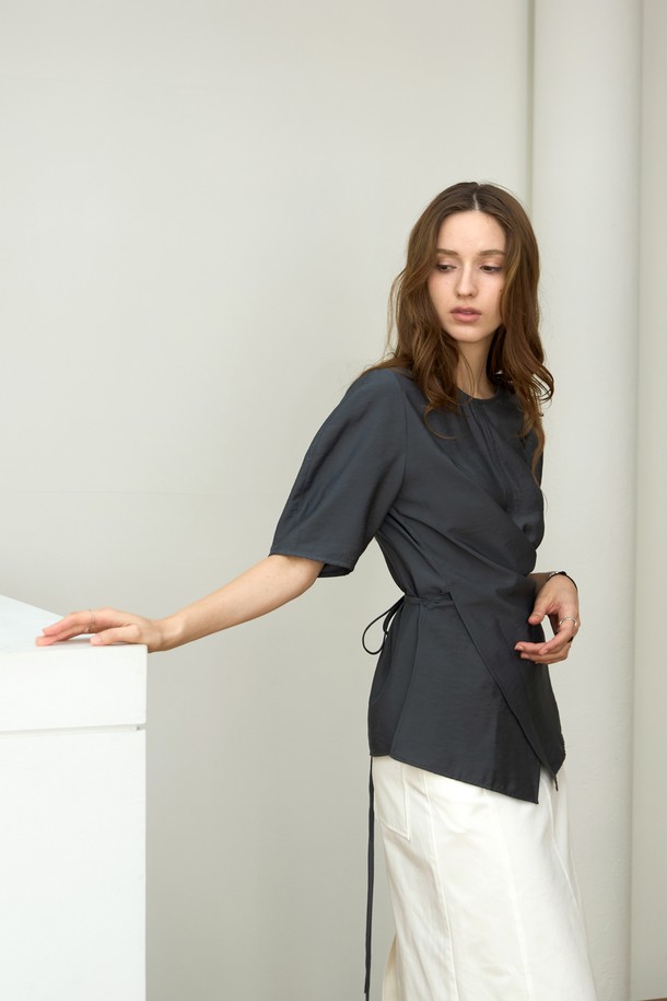 **라인 볼륨 랩 블라우스**

페미닌하고 우아한 무드의 여성 블라우스입니다. 부드러운 레이온과 나일론 혼방 소재로 제작되어 얇고 시원한 착용감을 선사합니다. 라운드 넥에 반소매, 레귤러 핏으로 데일리룩이나 데이트룩, 카페룩에 잘 어울립니다. 그레이, 그레이블루, 아이보리 세 가지 컬러로 출시되었으며, 스트라이프 패턴과 뒷목 버튼 여밈, 앞면 슬릿, 스트링 디테일, 벌룬 소매가 특징입니다.
