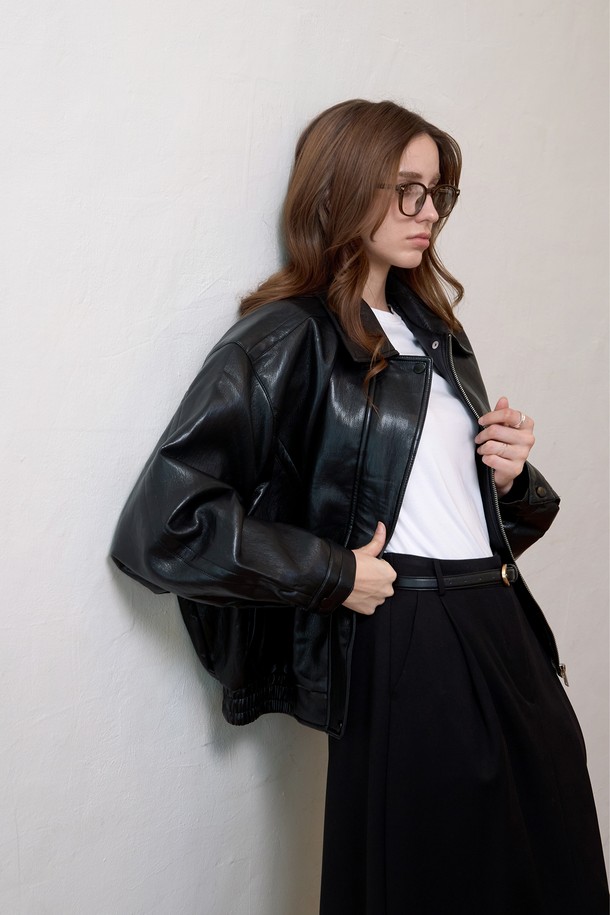 블랙 컬러의 페이크 레더 블루종 재킷입니다. 뻣뻣한 촉감과 두꺼운 두께감으로 제작되었으며, 오버핏 디자인으로 캐주얼하고 스트릿한 스타일을 연출합니다. 봄, 가을 시즌에 착용하기 좋으며, 일상 및 모임룩에 활용하기 좋습니다. 리브 디테일과 집업 방식으로 포인트를 더했으며, 긴 소매 기장으로 안정감을 줍니다.
