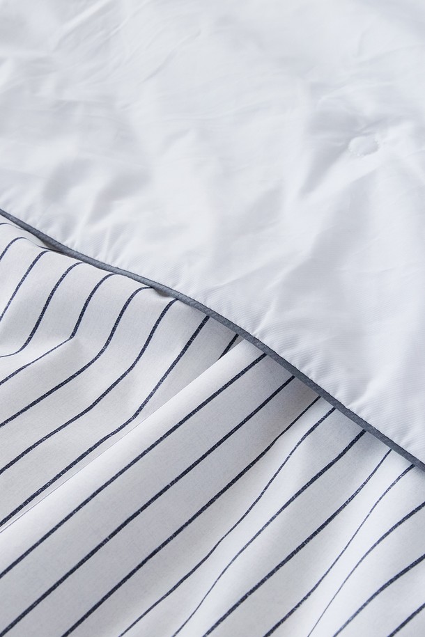 시원한 여름밤을 위한 아이스블롬 냉감 차렵이불 싱글 (그레이)입니다. 부드러운 40수 평직 면 100% 앞면과 두라론 냉감 폴리에스터 100% 뒷면으로 제작되어, 시원하고 쾌적한 잠자리를 제공합니다. 스칸디나비아 스타일의 스트라이프 패턴과 리버서블 디자인, 점프 킬팅 봉제 기법으로 세련된 디자인과 들뜨지 않는 사용감을 선사하며, 양면 사용이 가능하여 실용적입니다.
