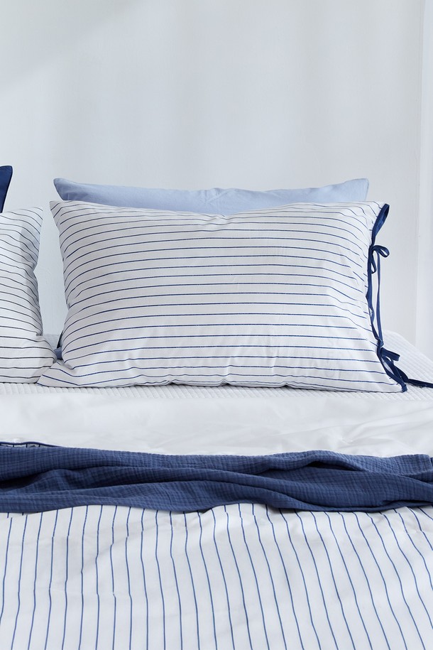 블롬 리본 순면 베개 커버 50x70은 부드러운 촉감의 순면 소재로 제작되어 흡습성과 통기성이 뛰어납니다. 스칸디나비안 스타일의 스트라이프 패턴과 리본 디테일이 돋보이며, 블루와 그레이 두 가지 색상 중 선택 가능합니다. 40수 평직으로 제작되어 튼튼하며, 봉투형 디자인과 프리미엄 스티칭 마감으로 완성도를 높였습니다. 유해 물질 테스트를 통과하여 안심하고 사용할 수 있는 베개 커버입니다.
