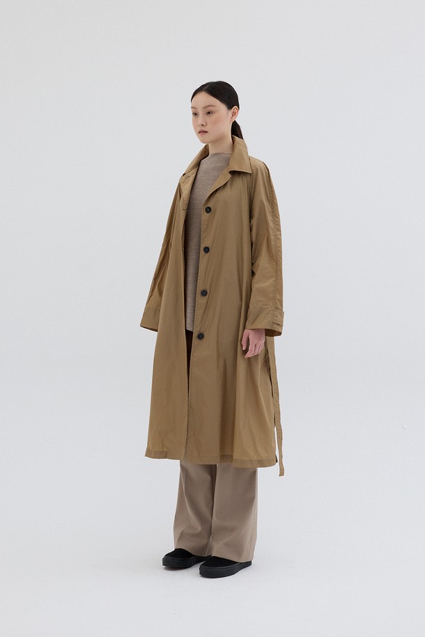 LIGHT WEIGHT TRENCH COAT_BEIGE (라이트 웨이트 트렌치 코트_베이지)는 여성용 아우터로, 봄과 가을에 어울리는 베이지 컬러의 롱 기장 트렌치코트입니다. 가볍고 부드러운 나일론 소재로 제작되어 편안한 착용감을 선사하며, 릴랙스 핏으로 여유로운 실루엣을 연출합니다. 클래식하고 베이직한 디자인에 라글란 슬리브, 오픈 칼라, 플리츠 디테일, 커스텀 버튼, 벨트 장식이 더해져 세련된 포인트를 더했습니다. 버튼과 벨트로 여밈이 가능하며, 데이트룩, 출근룩, 모임룩 등 다양한 TPO에 맞춰 클래식, 미니멀, 시크한 스타일을 연출할 수 있습니다.
