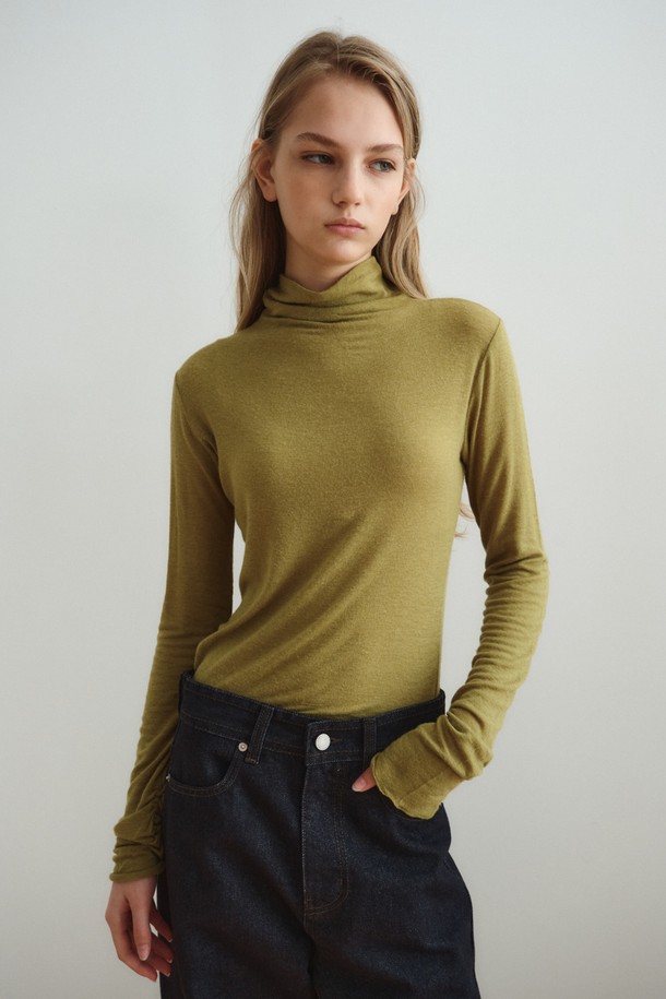 SOFT WOOL JERSEY TOP_올리브는 부드러운 촉감의 울 저지 소재로 제작된 여성 상의입니다. 올리브와 아이보리 두 가지 색상으로 출시되었으며, 가을과 겨울에 착용하기 좋습니다. 하이넥 디자인과 슬림핏으로 미니멀하고 시크한 스타일을 연출하며, 긴 소매와 소매 커프스 디테일이 특징입니다. 두꺼운 두께감으로 보온성을 높였으며, 스트레치 소재로 편안한 착용감을 선사합니다. 레이어드 스타일링이 가능하여 겨울 데일리룩, 오피스룩, 모임룩 등 다양한 TPO에 활용할 수 있습니다.
