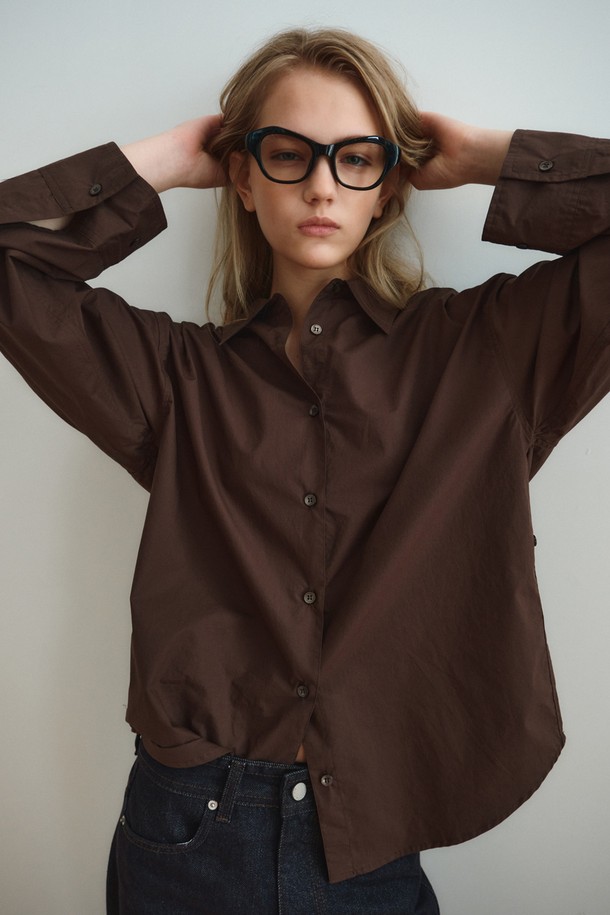 RELAXED COTTON SHIRT_DARK BROWN (릴랙스드 코튼 셔츠_다크 브라운)은 미니멀하고 베이직한 스타일의 여성 셔츠/블라우스입니다. 다크 브라운 컬러의 무지 디자인으로, 사계절 내내 활용 가능하며 출근룩과 모임룩에 적합합니다. 부드러운 촉감의 면 소재로 제작되었으며, 릴랙스핏과 루즈핏으로 편안한 착용감을 제공합니다. 얇은 두께의 레귤러 기장 셔츠로, 와이드 슬리브 디자인과 조절 가능한 소매 커프스가 특징이며, 레이어드하여 다양한 스타일을 연출할 수 있습니다. 차이나칼라와 긴 소매 디자인으로 미니멀, 클래식, 캐주얼 등 폭넓은 스타일을 소화할 수 있습니다.
