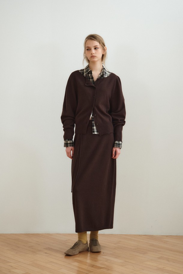 볼륨 롱 니트 스커트_다크 브라운은 부드러운 촉감의 울, 레이온, 나일론, 폴리에스터 혼방 소재로 제작된 여성용 니트 스커트입니다. 다크 브라운과 오트밀 두 가지 색상으로 제공되며, 간절기에 입기 좋은 중간 두께감의 롱 스커트입니다. 홀가먼트 니팅 기법으로 제작되어 자연스러운 드레이핑과 볼륨감 있는 A라인 실루엣을 연출하며, 매칭 스트랩이 포함되어 있습니다. 우아하고 베이직한 스타일로 데이트룩, 카페룩, 겨울 데일리룩 등 다양한 TPO에 활용할 수 있으며, 클래식하고 미니멀한 무드를 연출합니다.
