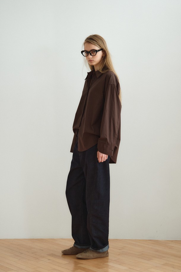 RELAXED COTTON SHIRT_DARK BROWN (릴랙스드 코튼 셔츠_다크 브라운)은 미니멀하고 베이직한 스타일의 여성 셔츠/블라우스입니다. 다크 브라운 컬러의 무지 디자인으로, 사계절 내내 활용 가능하며 출근룩과 모임룩에 적합합니다. 부드러운 촉감의 면 소재로 제작되었으며, 릴랙스핏과 루즈핏으로 편안한 착용감을 제공합니다. 얇은 두께의 레귤러 기장 셔츠로, 와이드 슬리브 디자인과 조절 가능한 소매 커프스가 특징이며, 레이어드하여 다양한 스타일을 연출할 수 있습니다. 차이나칼라와 긴 소매 디자인으로 미니멀, 클래식, 캐주얼 등 폭넓은 스타일을 소화할 수 있습니다.

