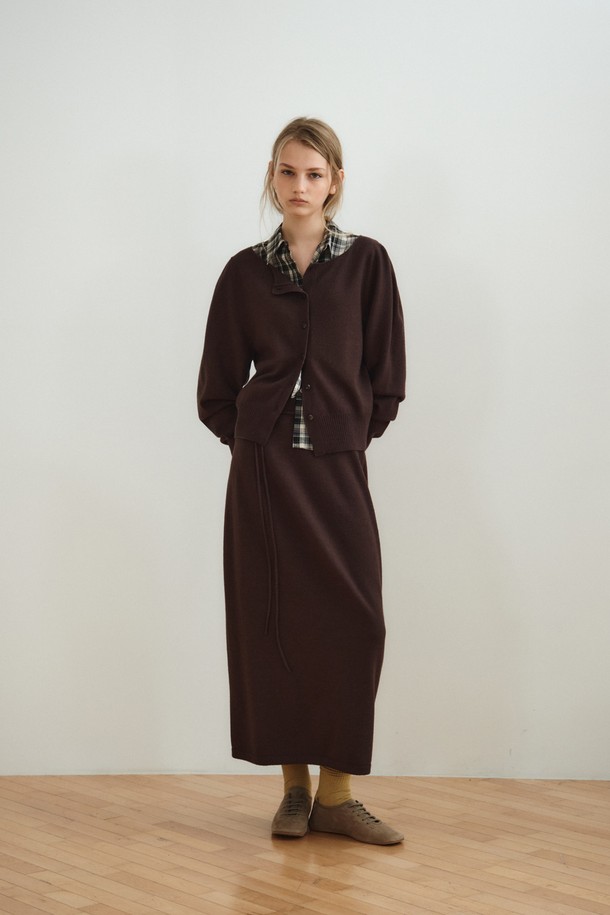 볼륨 롱 니트 스커트_다크 브라운은 부드러운 촉감의 울, 레이온, 나일론, 폴리에스터 혼방 소재로 제작된 여성용 니트 스커트입니다. 다크 브라운과 오트밀 두 가지 색상으로 제공되며, 간절기에 입기 좋은 중간 두께감의 롱 스커트입니다. 홀가먼트 니팅 기법으로 제작되어 자연스러운 드레이핑과 볼륨감 있는 A라인 실루엣을 연출하며, 매칭 스트랩이 포함되어 있습니다. 우아하고 베이직한 스타일로 데이트룩, 카페룩, 겨울 데일리룩 등 다양한 TPO에 활용할 수 있으며, 클래식하고 미니멀한 무드를 연출합니다.
