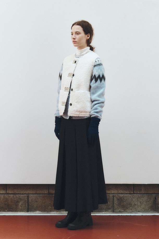 아이보리 컬러의 리버시블 셔링 베스트입니다. 양털과 쉬어링 소재로 제작되어 부드러운 촉감과 두꺼운 두께감으로 따뜻하게 착용할 수 있습니다. 가을, 겨울 시즌에 어울리는 레귤러 핏의 민소매 베스트로, 버튼 여밈 방식과 무지 디자인이 클래식하고 미니멀한 스타일을 연출합니다. 양면 착용이 가능하여 다양한 스타일로 활용할 수 있는 실용적인 아우터입니다. 데일리룩을 완성하는 데 적합한 아이템입니다.
