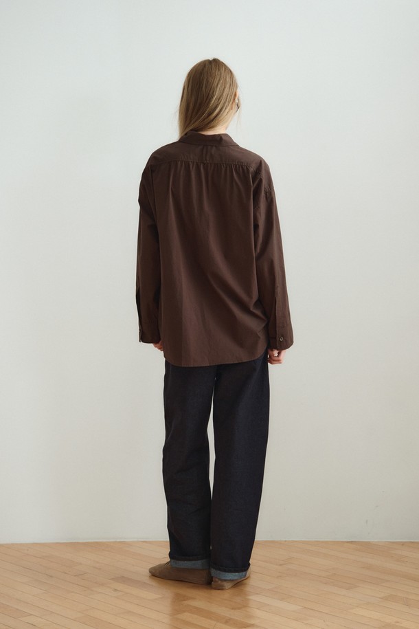 RELAXED COTTON SHIRT_DARK BROWN (릴랙스드 코튼 셔츠_다크 브라운)은 미니멀하고 베이직한 스타일의 여성 셔츠/블라우스입니다. 다크 브라운 컬러의 무지 디자인으로, 사계절 내내 활용 가능하며 출근룩과 모임룩에 적합합니다. 부드러운 촉감의 면 소재로 제작되었으며, 릴랙스핏과 루즈핏으로 편안한 착용감을 제공합니다. 얇은 두께의 레귤러 기장 셔츠로, 와이드 슬리브 디자인과 조절 가능한 소매 커프스가 특징이며, 레이어드하여 다양한 스타일을 연출할 수 있습니다. 차이나칼라와 긴 소매 디자인으로 미니멀, 클래식, 캐주얼 등 폭넓은 스타일을 소화할 수 있습니다.
