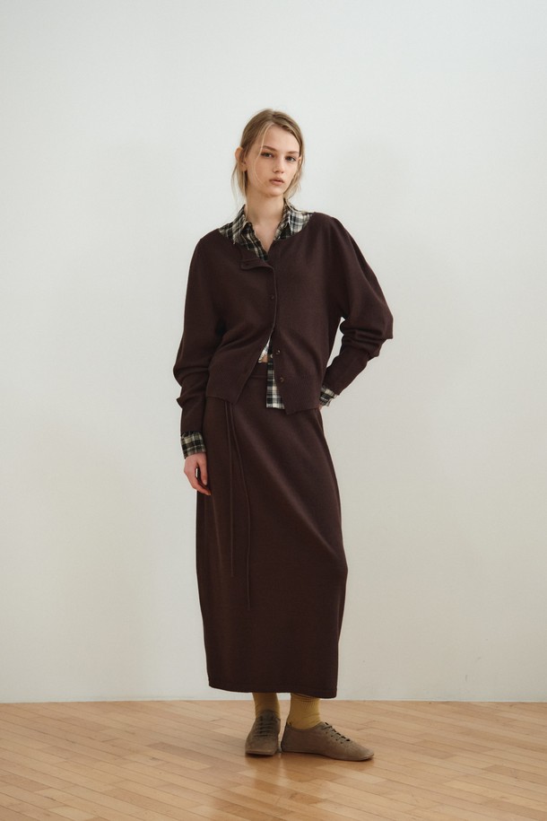 볼륨 롱 니트 스커트_다크 브라운은 부드러운 촉감의 울, 레이온, 나일론, 폴리에스터 혼방 소재로 제작된 여성용 니트 스커트입니다. 다크 브라운과 오트밀 두 가지 색상으로 제공되며, 간절기에 입기 좋은 중간 두께감의 롱 스커트입니다. 홀가먼트 니팅 기법으로 제작되어 자연스러운 드레이핑과 볼륨감 있는 A라인 실루엣을 연출하며, 매칭 스트랩이 포함되어 있습니다. 우아하고 베이직한 스타일로 데이트룩, 카페룩, 겨울 데일리룩 등 다양한 TPO에 활용할 수 있으며, 클래식하고 미니멀한 무드를 연출합니다.
