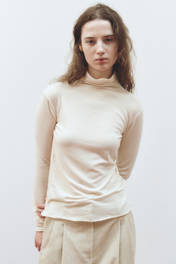 SOFT WOOL JERSEY TOP_브라운은 부드러운 울 소재로 제작된 여성용 하이넥 긴소매 상의입니다. 가을, 겨울 시즌에 어울리는 두꺼운 두께감으로 포근하게 착용할 수 있으며, 레귤러 핏으로 편안함을 더했습니다. 미니멀하고 베이직한 디자인으로 출근룩은 물론 다양한 일상 스타일에도 활용하기 좋습니다. 브라운 색상과 무지 패턴은 어떤 하의에도 매치하기 용이하며, 버튼 디테일이 은은한 포인트를 더합니다.
