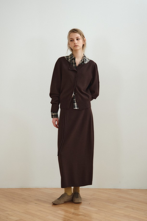 볼륨 롱 니트 스커트_다크 브라운은 부드러운 촉감의 울, 레이온, 나일론, 폴리에스터 혼방 소재로 제작된 여성용 니트 스커트입니다. 다크 브라운과 오트밀 두 가지 색상으로 제공되며, 간절기에 입기 좋은 중간 두께감의 롱 스커트입니다. 홀가먼트 니팅 기법으로 제작되어 자연스러운 드레이핑과 볼륨감 있는 A라인 실루엣을 연출하며, 매칭 스트랩이 포함되어 있습니다. 우아하고 베이직한 스타일로 데이트룩, 카페룩, 겨울 데일리룩 등 다양한 TPO에 활용할 수 있으며, 클래식하고 미니멀한 무드를 연출합니다.
