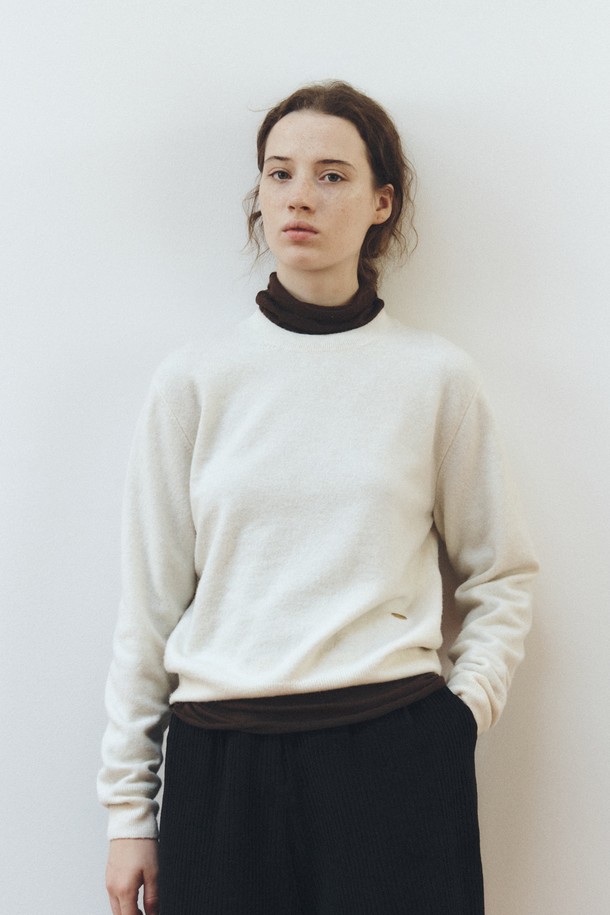 소프트 울 라운드넥 니트 탑_크림은 부드러운 촉감의 소프트 울 소재로 제작되어 가을과 겨울에 따뜻하게 착용하기 좋습니다. 베이직하고 미니멀한 디자인으로 일상, 출근룩, 모임룩 등 다양한 TPO에 활용할 수 있습니다. 레귤러 핏에 라운드넥, 긴 소매 기장으로 클래식, 미니멀, 캐주얼 스타일을 모두 소화하며, 두꺼운 두께감으로 포근함을 더합니다. 크림 컬러의 무지 디자인은 어떤 하의와도 쉽게 매치되어 활용도가 높습니다.
