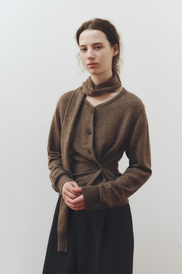 SCARF WOOL BLEND CARDIGAN_BROWN(스카프 울 블렌드 가디건_브라운)은 여성 고객을 위한 가을, 겨울용 상의입니다. 부드러운 촉감의 울 및 울 혼방 소재로 제작되었으며, 라운드 넥에 레귤러핏으로 디자인되었습니다. 차분하고 세련된 브라운 컬러에 무지 패턴으로, 베이직하면서도 클래식한 스타일을 연출합니다. 긴 소매 기장과 두께감 있는 소재로 따뜻함을 더하며, 스카프 디테일과 버튼 여밈 방식으로 포인트를 주었습니다. 오피스룩, 출근룩, 모임룩 등 다양한 TPO에 활용 가능하며, 미니멀하고 클래식한 스타일을 선호하는 고객에게 적합합니다.
