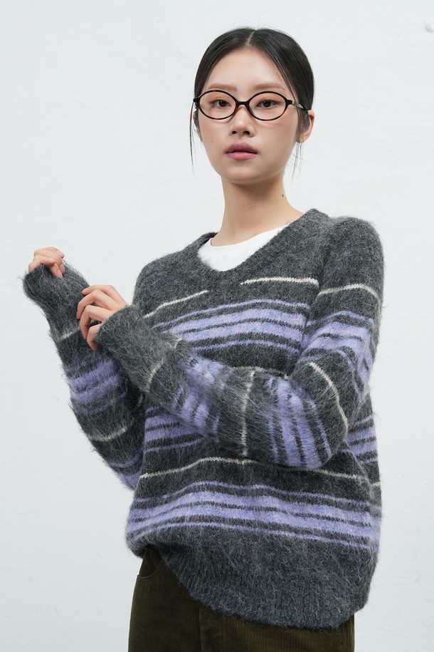 [25FW] WOMAN 헤어리 스트라이프 루즈 풀오버는 부드러운 헤어리 촉감과 브이넥 디자인이 돋보이는 여성용 니트 스웨터입니다. 가을, 겨울 시즌에 적합하며, 울 혼방 소재로 제작되어 따뜻하고 포근한 착용감을 선사합니다. 

레드 브라운, 차콜 두 가지 색상으로 출시되었으며, 루즈핏과 긴 소매 기장으로 편안한 캐주얼 스타일을 연출합니다. 브러시 가공과 새들 숄더 디자인이 특징이며, 스트라이프 패턴이 세련된 포인트를 더합니다. 

일상, 카페, 모임 등 다양한 TPO에 활용할 수 있으며, 캐주얼, 클래식, 미니멀 스타일을 즐기는 여성에게 추천합니다. 
